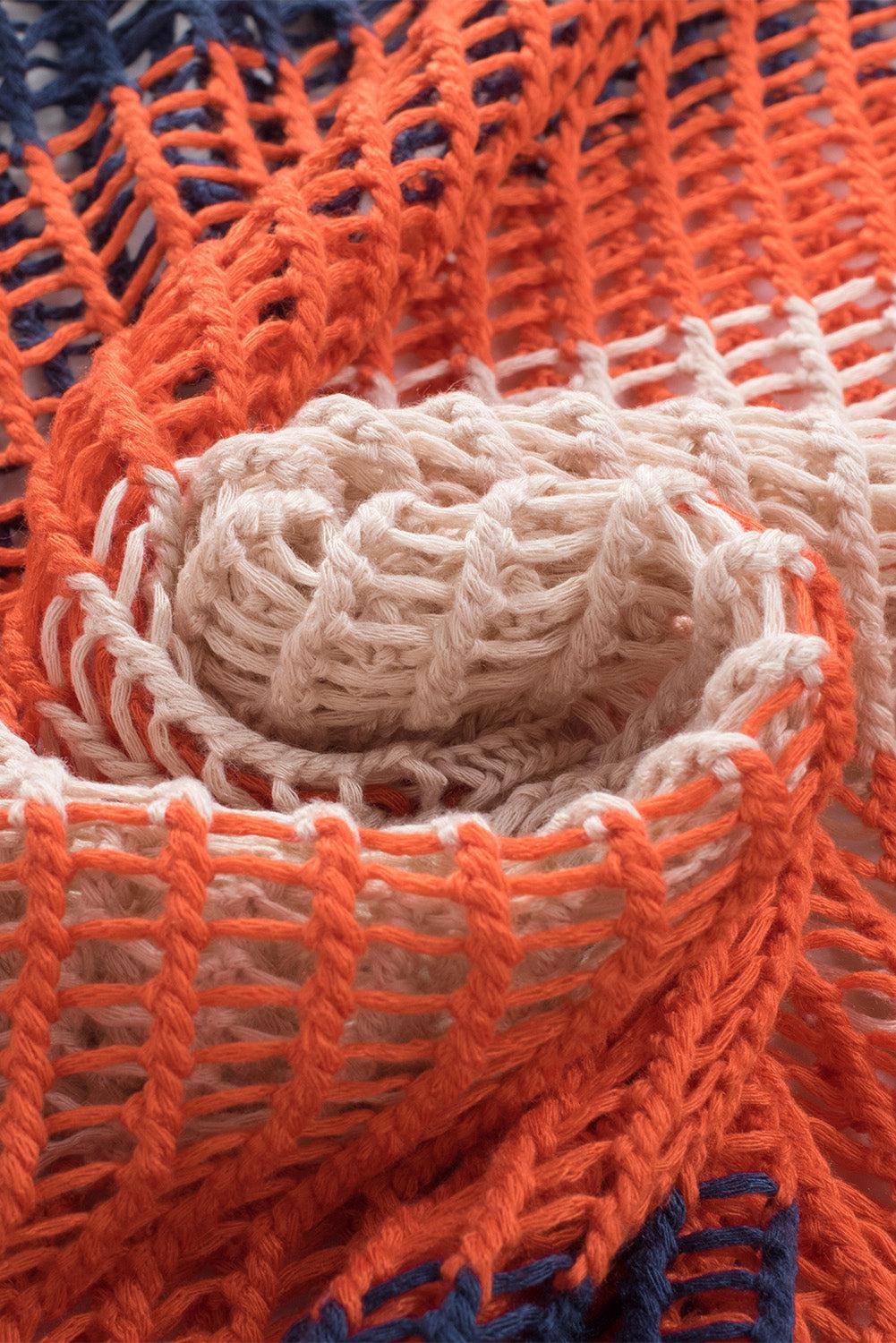 a close up of an orange and blue knitted blanket