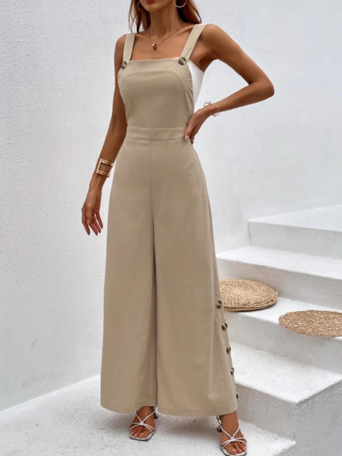 a woman wearing a tan jumpsuit and sandals