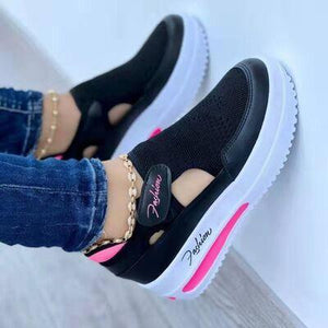 a close up of a person wearing black and pink shoes