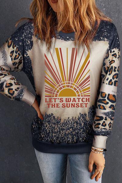 a woman with long hair wearing a sweater with a sun design