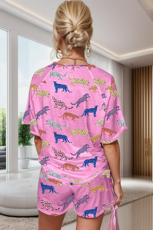 a woman wearing a pink pajamasuit with giraffes on it