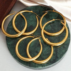 a group of gold hoop earrings sitting on top of a green plate