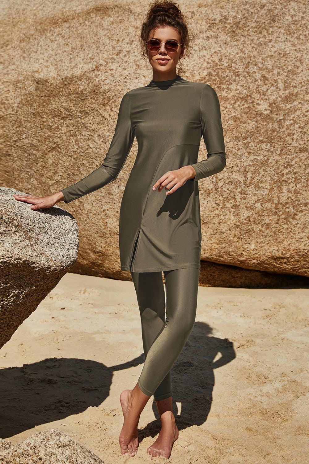 a woman in a wet suit standing on a rock