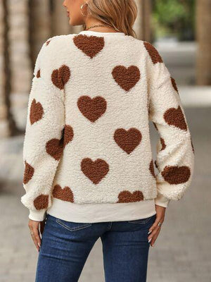 a woman wearing a sweater with hearts on it