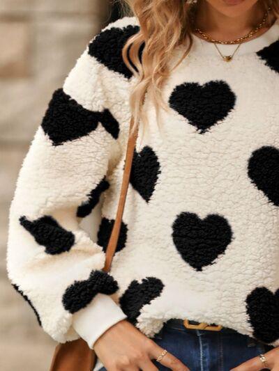 a woman wearing a black and white polka dot sweater