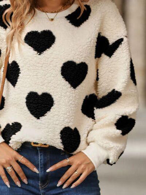 a woman wearing a black and white polka dot sweater