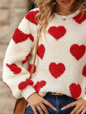 a woman wearing a sweater with hearts on it