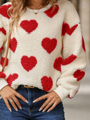 a woman wearing a sweater with hearts on it