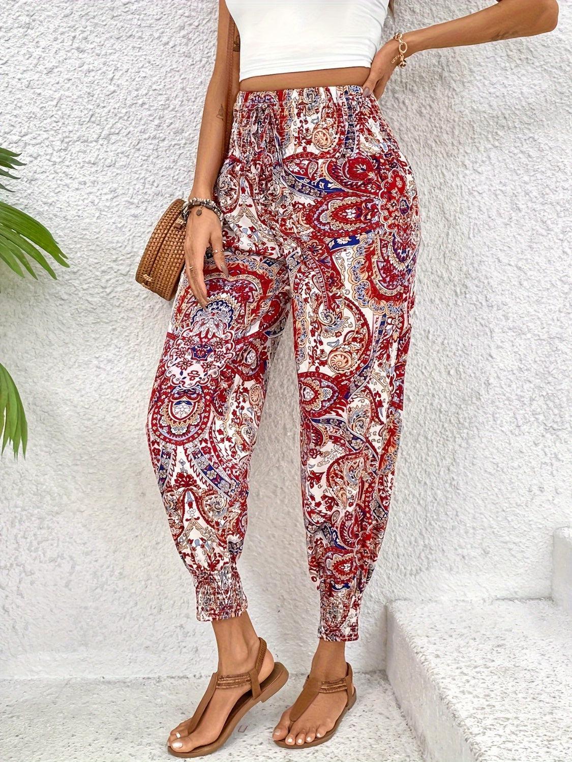 a woman in a white top and red paisley print pants