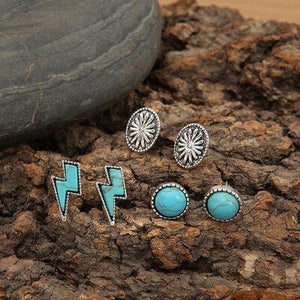 a pair of earrings sitting on top of a rock