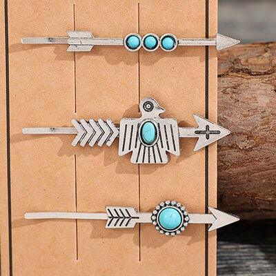 a set of four turquoise and silver arrow brooches