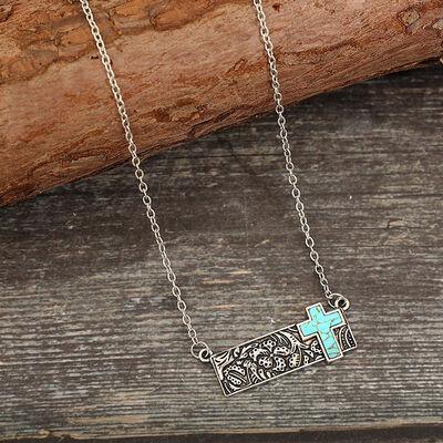 a silver necklace with a turquoise cross on it