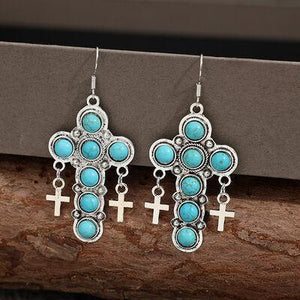 a pair of earrings with crosses and turquoise stones