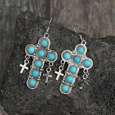 a pair of earrings with crosses and turquoise stones