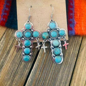 a pair of earrings with crosses and turquoise stones