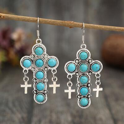 a pair of earrings with crosses and turquoise stones