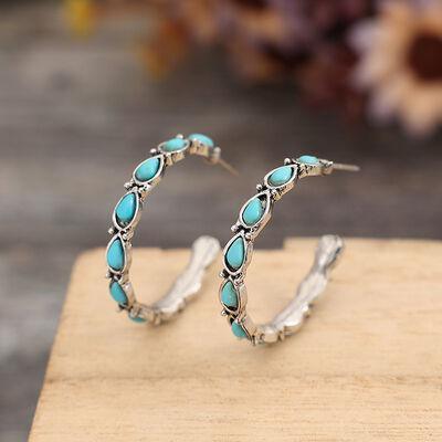 a pair of silver hoop earrings with turquoise stones