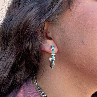 a close up of a person wearing a pair of earrings