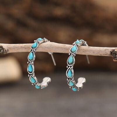 a pair of turquoise stone hoop earrings on a branch