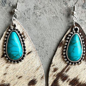 a pair of earrings with a turquoise stone in the center