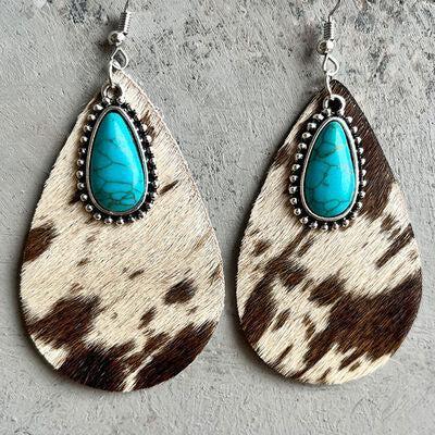 a pair of earrings with a turquoise stone in the center