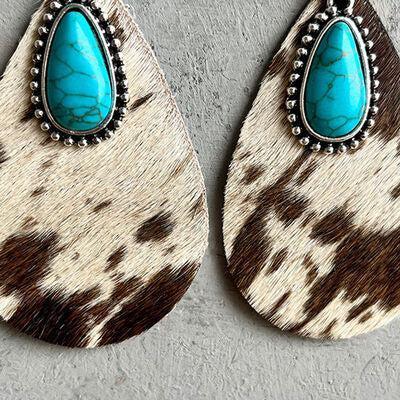 a pair of earrings with a turquoise stone in the center