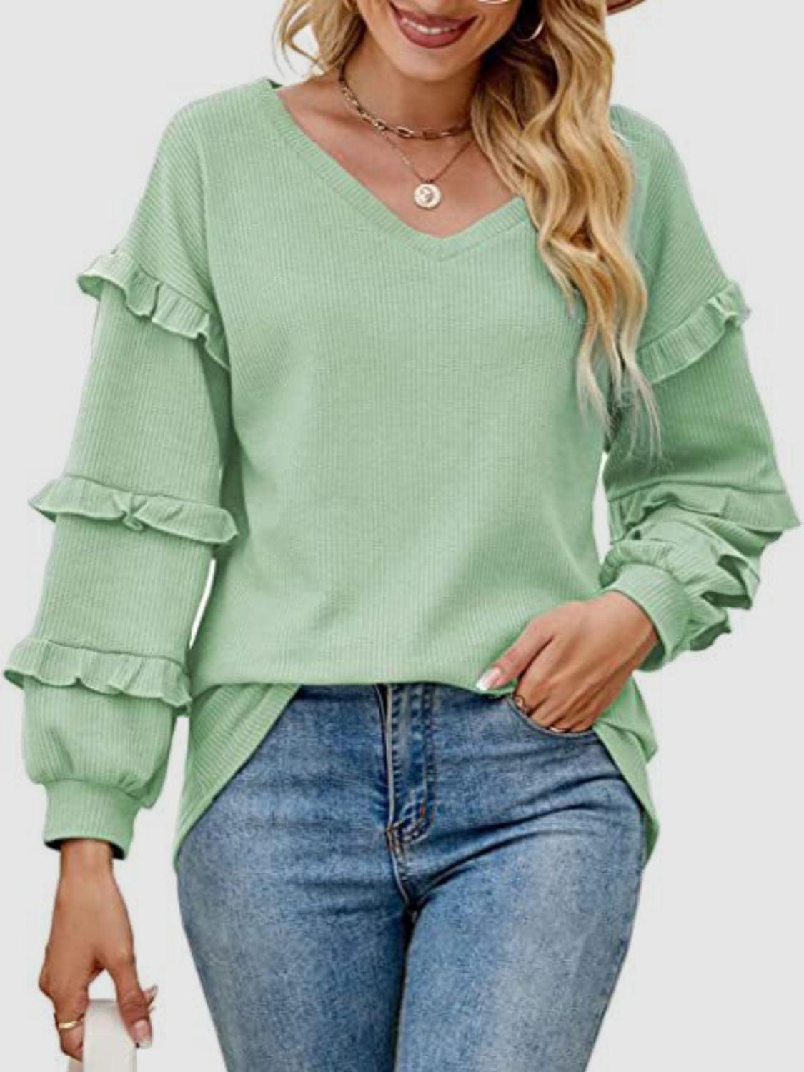 a woman wearing a green sweater and jeans