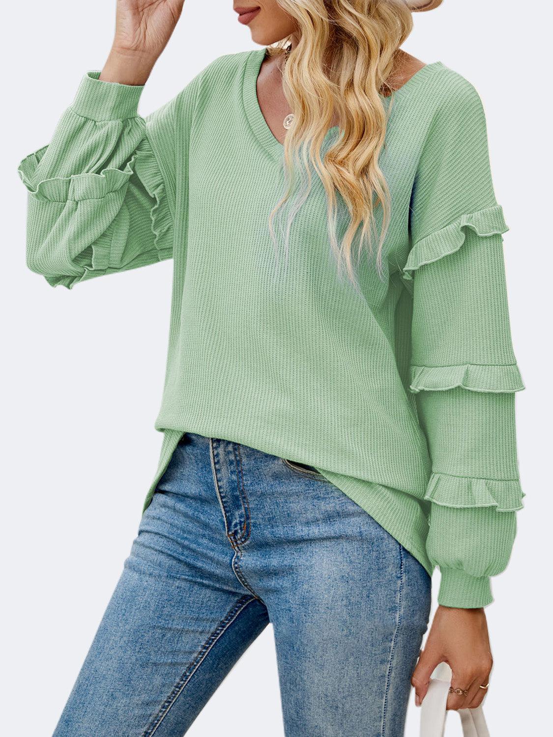 a woman wearing a green sweater and jeans