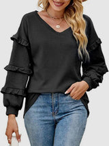 a woman wearing a black sweater and jeans