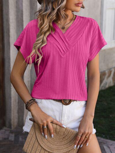 a woman wearing a pink top and white shorts