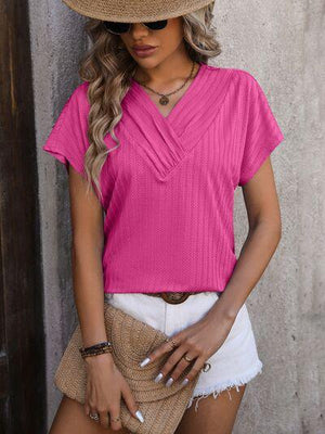 a woman wearing a pink top and white shorts