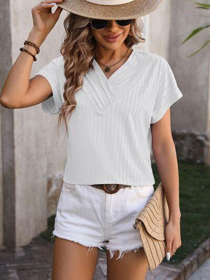 a woman wearing a straw hat and white shirt