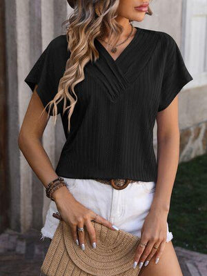 a woman wearing a black top and white shorts