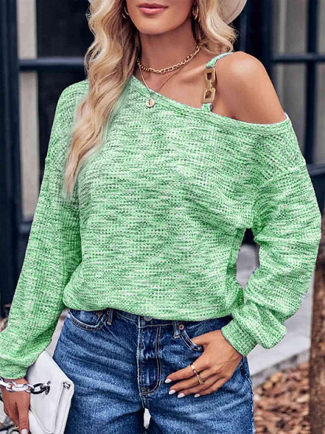 a woman wearing a green sweater and jeans