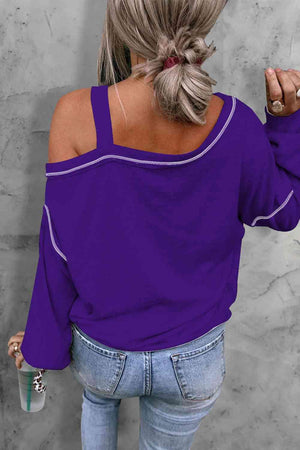 a woman with blonde hair wearing a purple top