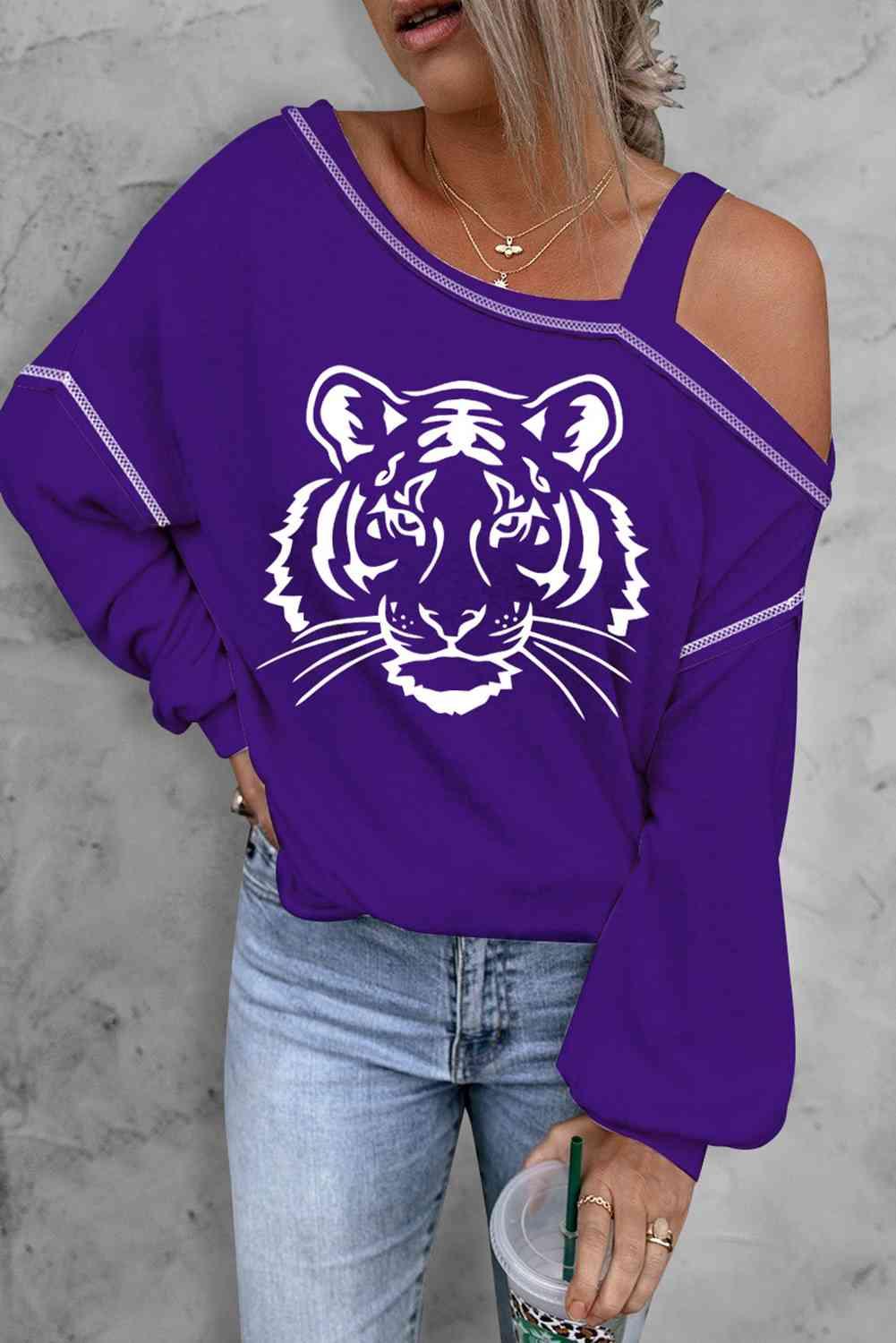 a woman wearing a purple tiger sweatshirt