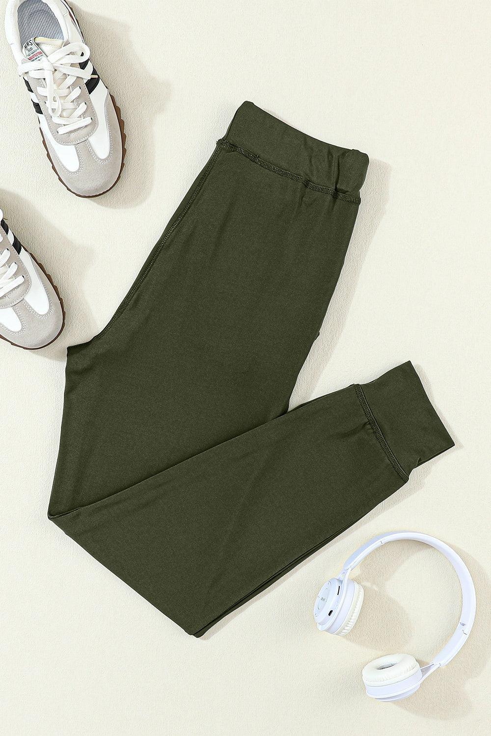 a pair of green pants, headphones and a pair of white sneakers