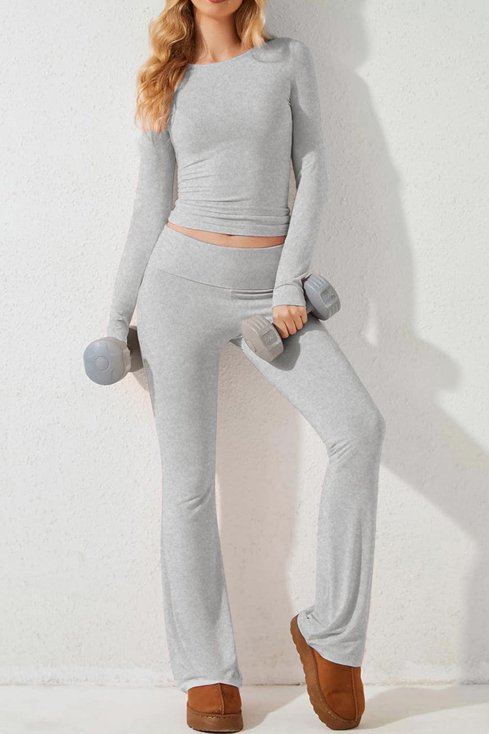 a woman is posing in a gray outfit