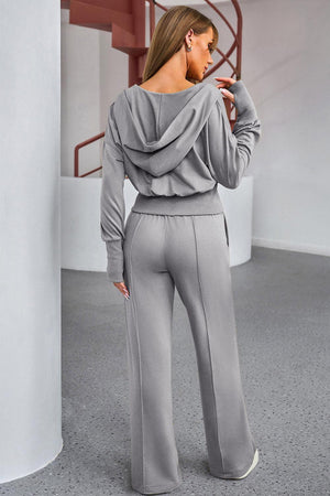 a woman in grey pants and a hoodie