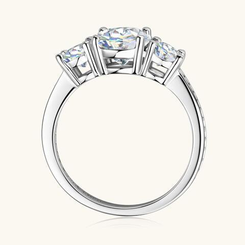 a three stone diamond ring on a white background