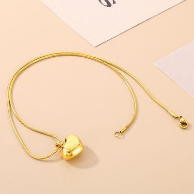 a gold necklace with a heart charm on a table