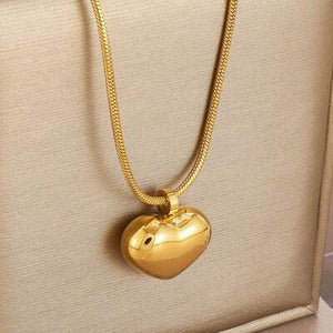 a gold heart shaped pendant on a gold chain