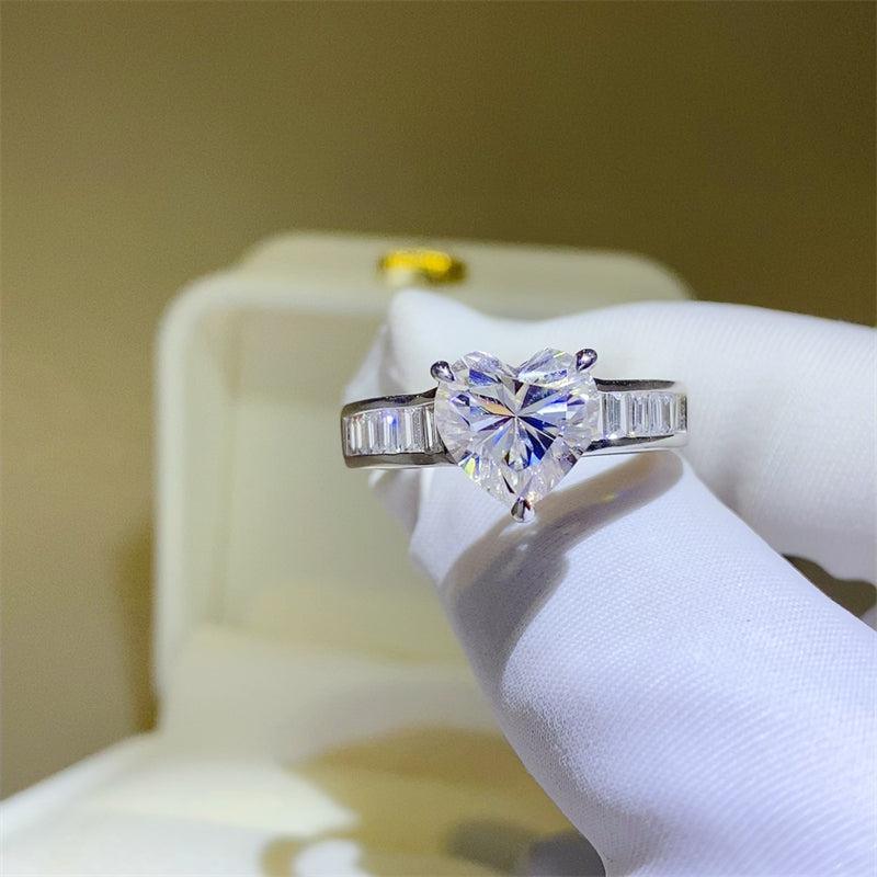 a heart shaped diamond ring on a white glove