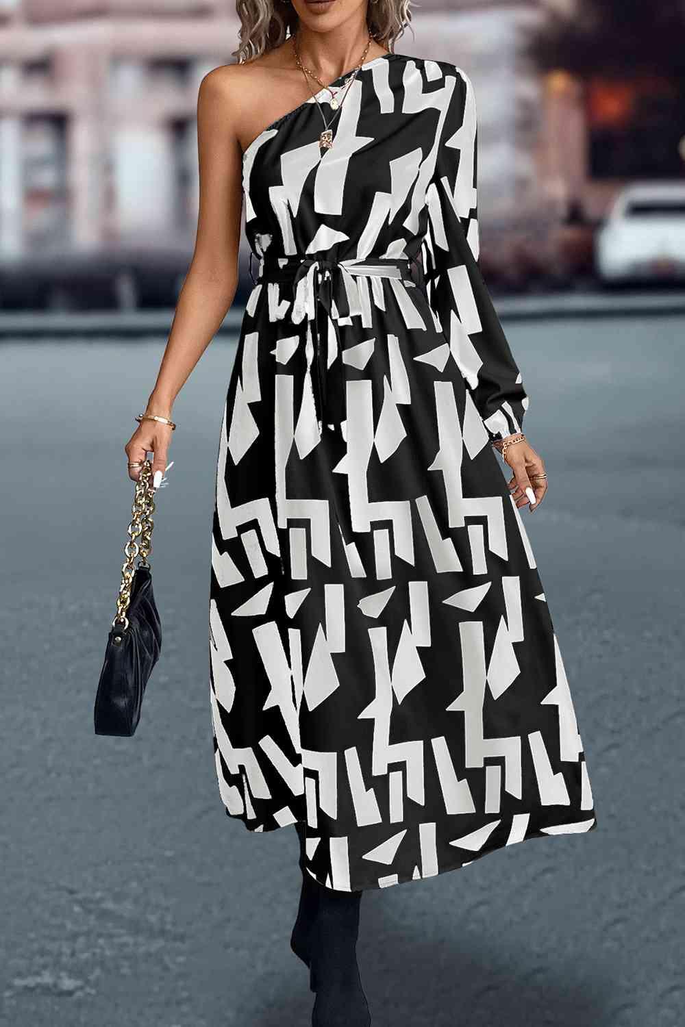 a woman in a black and white one shoulder dress