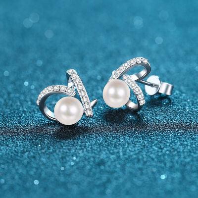 a pair of pearl and diamond earrings on a blue background