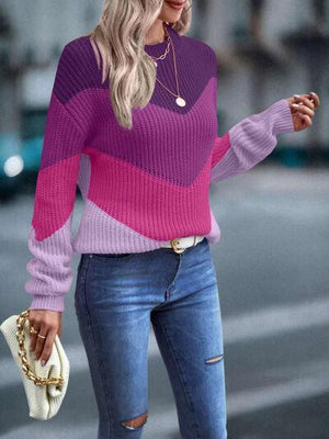 a woman wearing a pink and purple sweater and ripped jeans
