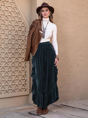 a woman wearing a hat and a long skirt