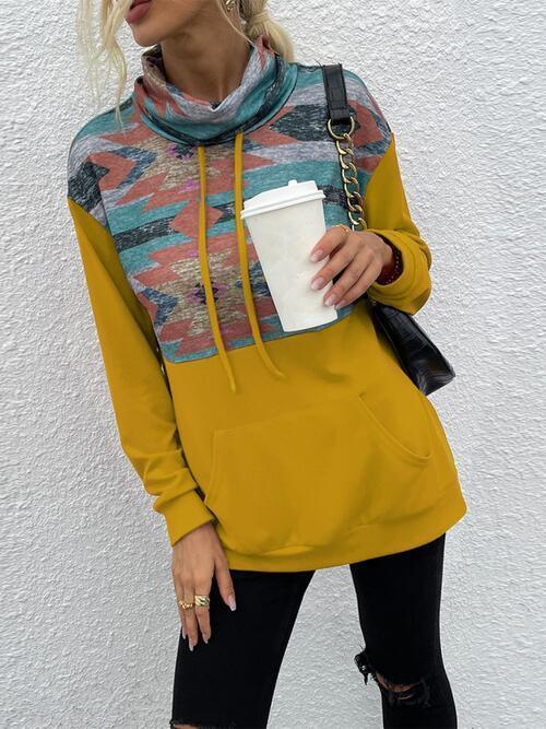 a woman wearing a yellow hoodie and ripped jeans