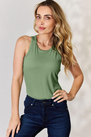 a woman in a green tank top posing for a picture