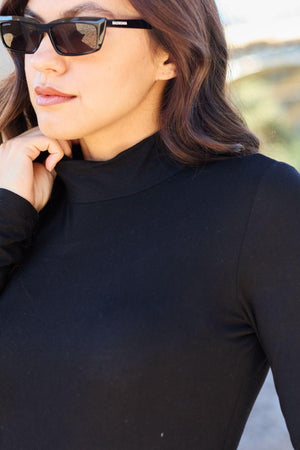 a woman wearing sunglasses and a black top